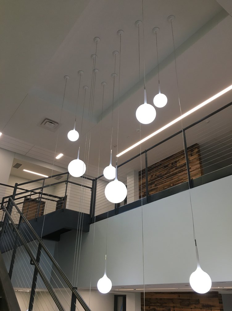 Large-scale industrial electrical installation by C&G Electric Inc — rows of gray electrical enclosures and disconnect panels on a raised blue mezzanine platform, North Texas industrial facility