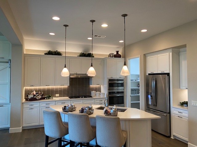 C&G Electric Inc residential kitchen lighting — pendant lights over curved island with recessed lighting throughout in a North Texas home