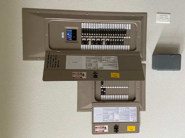 Residential panel upgrade by C&G Electric Inc — old small panel beside new larger Square D panel with digital display, professionally installed in a Krum, TX home