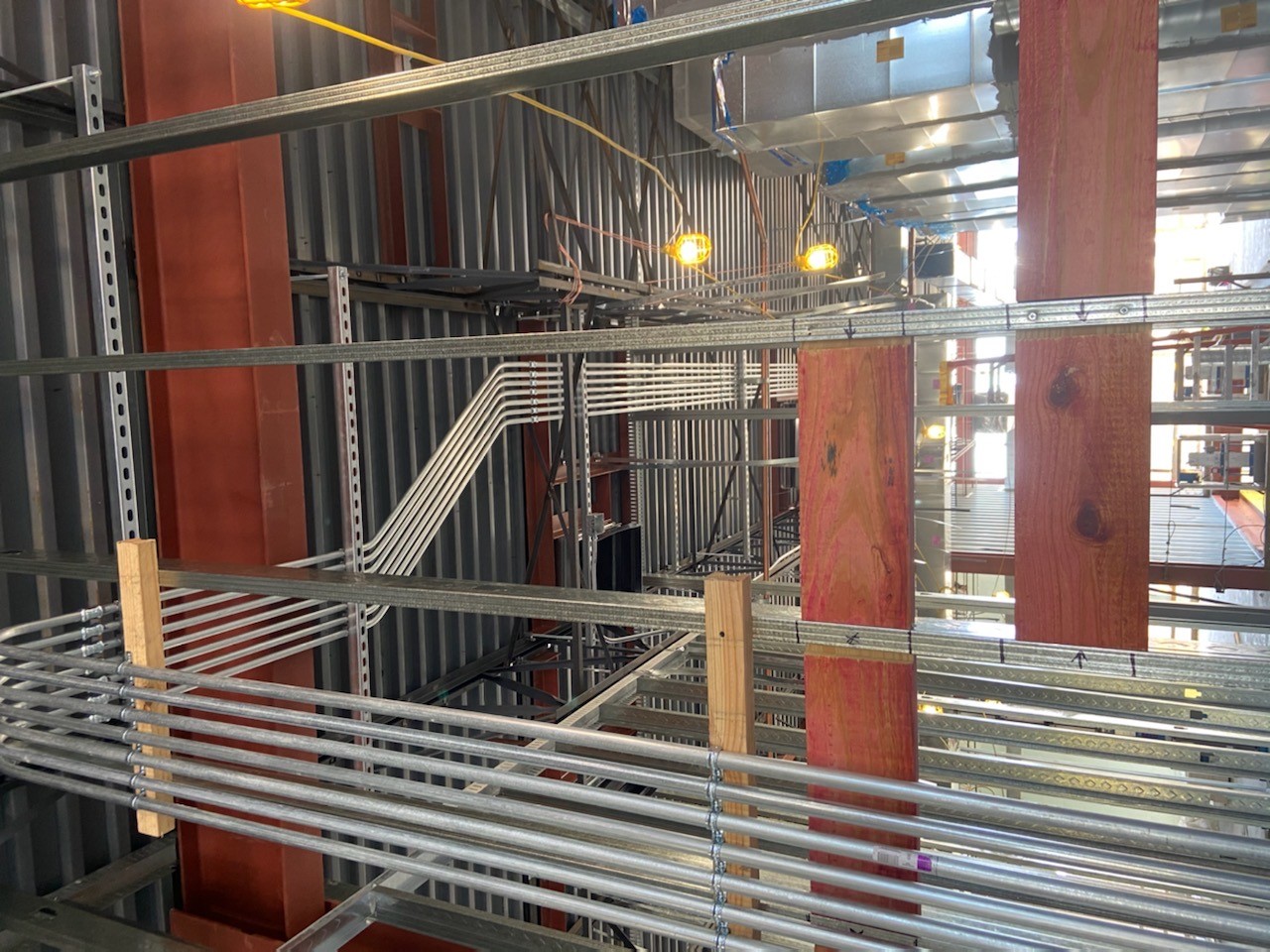 Commercial electrical installation by C&G Electric Inc — galvanized EMT conduit runs through steel stud framing in a large North Texas commercial building